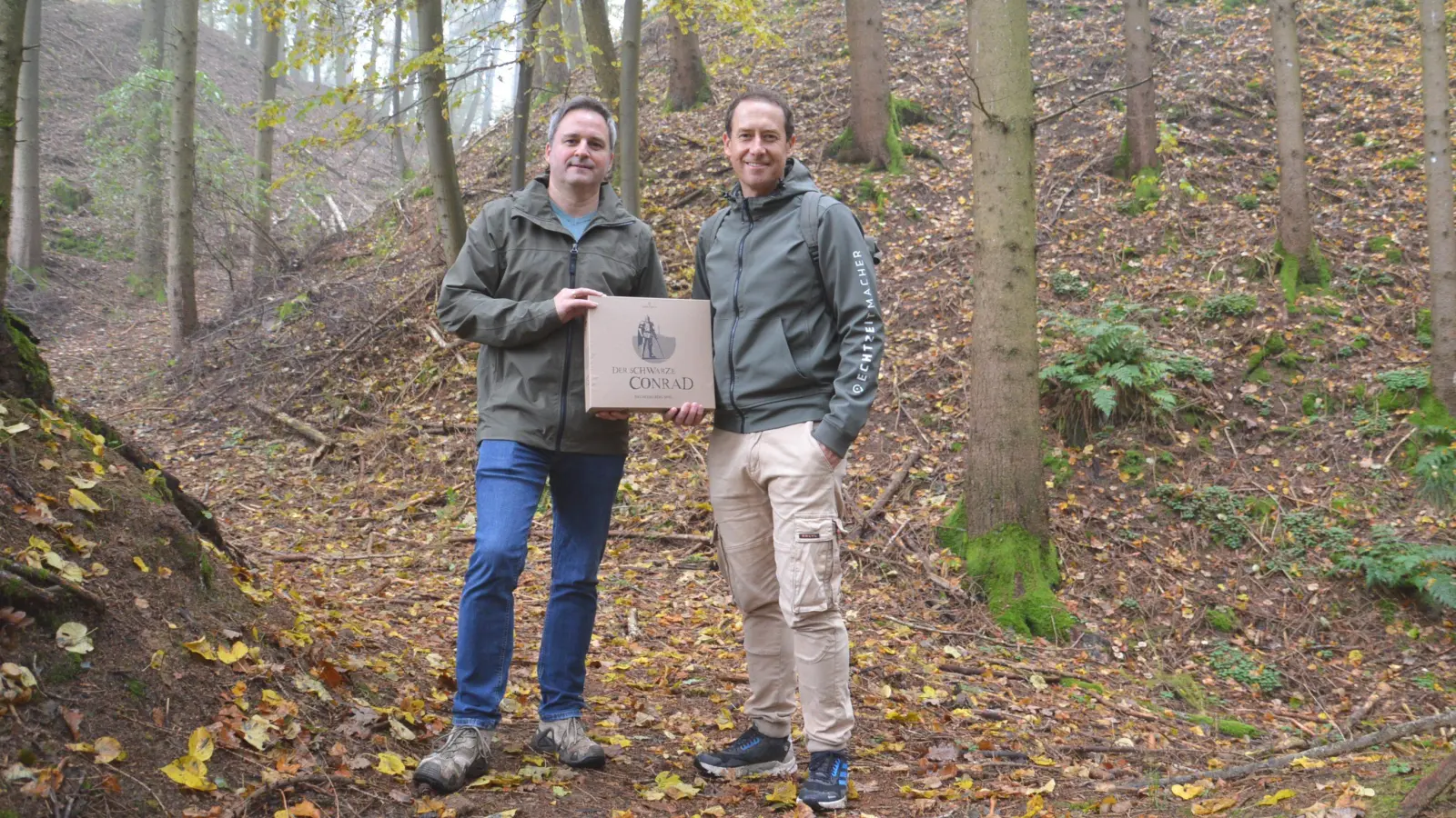 Am Originalschauplatz am Schlössleinsbuck, dem ehemaligen Standort der Burg vom „schwarzen“ Conrad, präsentieren Stefan Hofecker (links) und René Urban ihr Brettspiel rund um den Raubritter. (Foto: Peter Tippl)