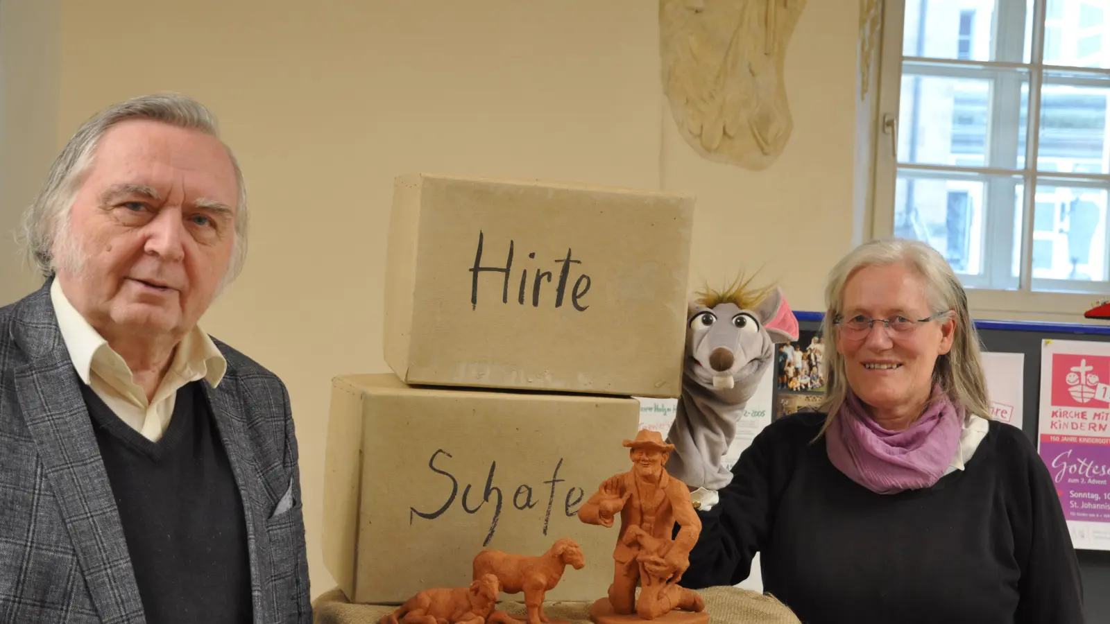 Der langjährige Kindergottesdienst-Helfer Reinhard Baran und Pfarrerin Dörte Knoch zeigen die Tonfiguren der Krippe und das Maskottchen für die (Foto: Jonas Volland)