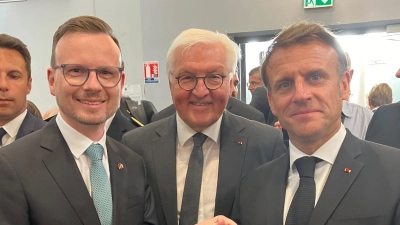 Bezirkstagspräsident Peter Daniel Forster sprach in Oradour mit Bundespräsident Frank-Walter Steinmeier und Staatspräsident Emmanuel Macron (von links). Er hatte für sie einen Europa-Wein aus Ipsheim und ein Buch über die kommunalen Freundschaften mitgebracht. (Foto: Bezirk Mittelfranken/Wolf Dieter Enser)