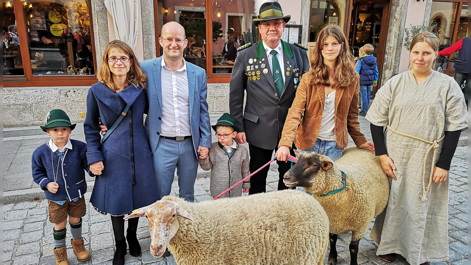 Die Schafe Berta (hinten) und Charlotte machten, geführt von Martina Wallek und Josefine Molitor (von rechts), bereitwillig mit bei der Prozedur, die Schützenmeister Michael Ehrlinger (Mitte) als einen Höhepunkt im Jahreskalender der Gilde bezeichnete. OB Dr. Markus Naser und seine Frau Nadine freuten sich mit. Auch die Buben Toni und Felix Rippstein waren bei der Zeremonie vorne dabei. (Foto: Jürgen Binder)