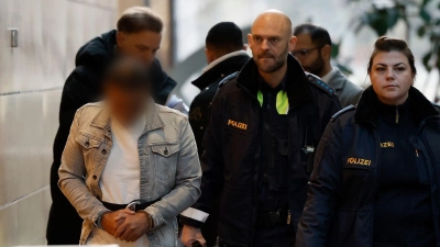 Der Angeklagte (l) wird in Handschellen zum Sitzungssaal im Landgericht Würzburg gebracht. (Foto: Heiko Becker/dpa)