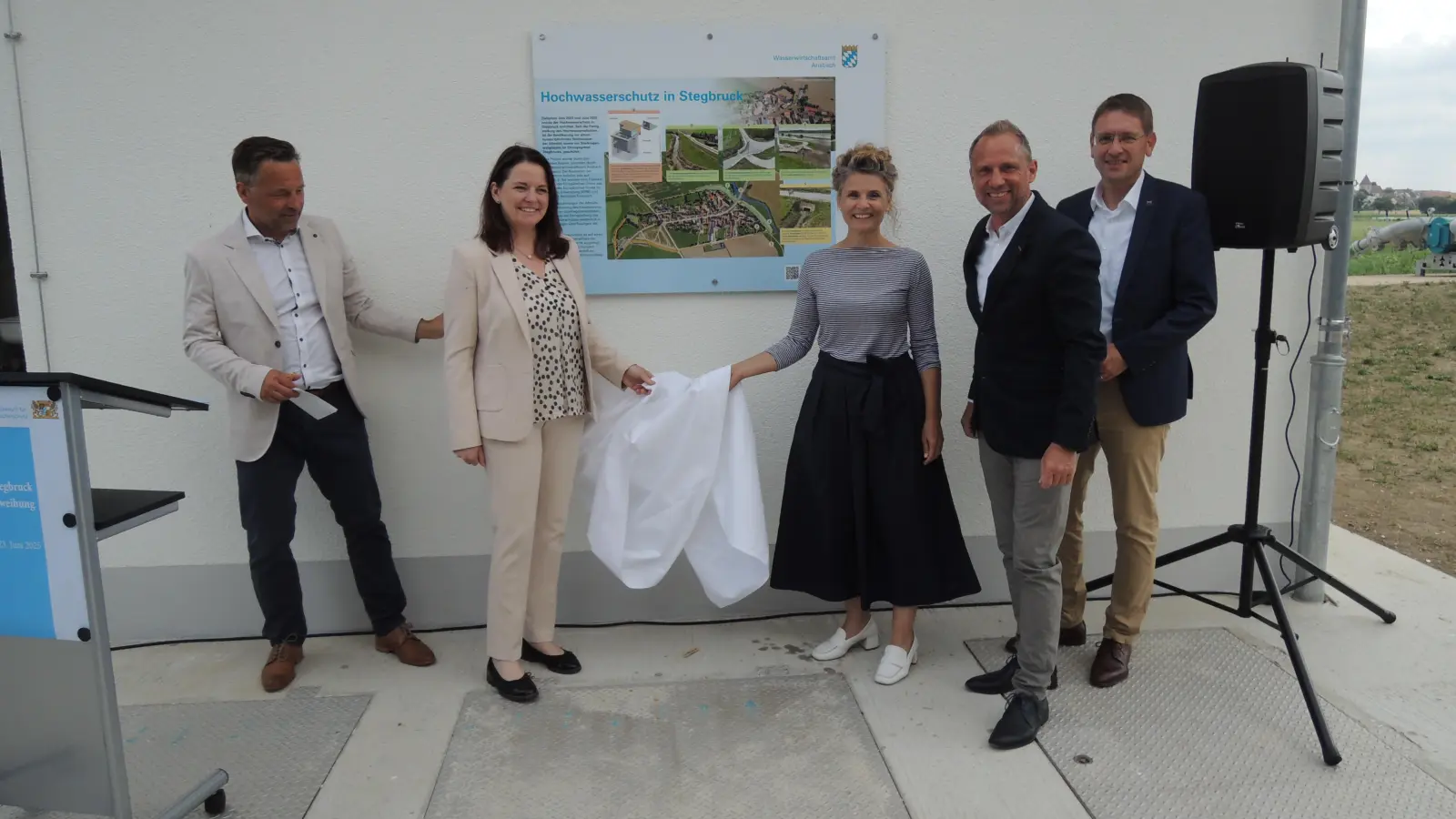 Informationen zum Hochwasserschutz in Stegbruck finden Interessierte am neuen Schöpfwerk auf einer Tafel: Diese enthüllten Wasserwirtschaftsamtsleiter Thomas Keller, Mittelfrankens Regierungspräsidentin Dr. Kerstin Engelhardt-Blum, Herriedens Bürgermeisterin Dorina Jechnerer, Staatsminister Thorsten Glauber und Landrat Dr. Jürgen Ludwig (von links). (Foto: Peter Zumach)