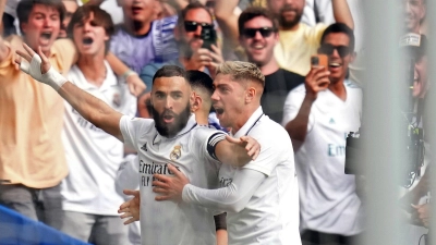 Real-Torschütze Karim Benzema (l) lässt sich von Federico Valverde und den Fans feiern. (Foto: Manu Fernandez/AP/dpa)