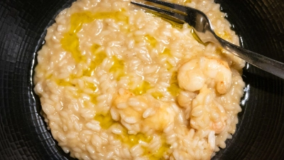 Kurz vorm Servieren gibt Küchenchef Kruno Kapetanović noch einen Schuss Olivenöl über das Scampi-Risotto. (Foto: Andreas Drouve/dpa-tmn)