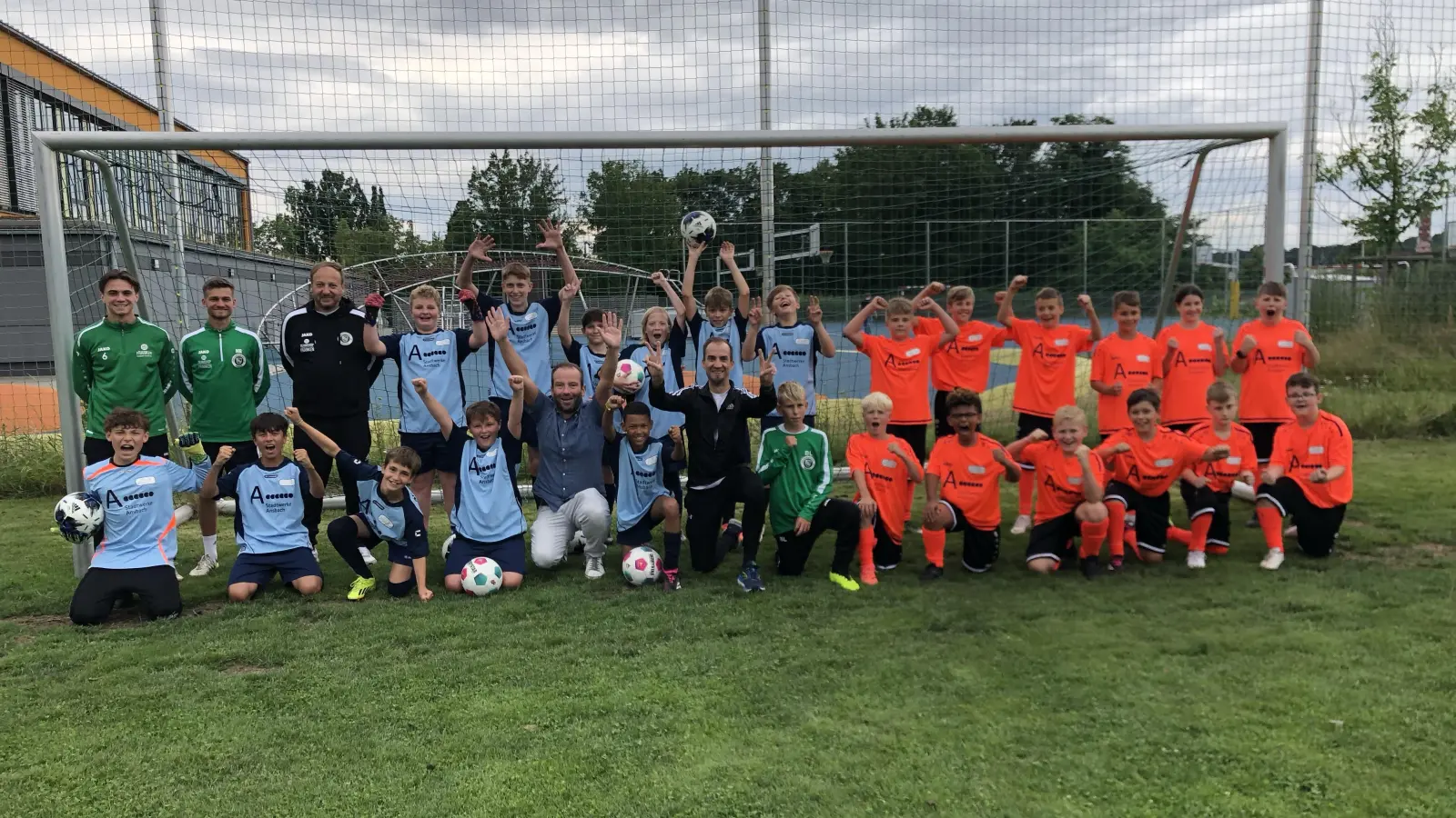 Gruppenbild mit „großen“ Fußballern: Die 5a und die 6a der Staatlichen Realschule freuten sich über den Besuch von Christian Kestel, Niklas Reutelhuber und Marco Schülein (oben, von links). Schulleiter Thomas Häckel (vorne, Fünfter von links) und Fachlehrer Marco Flassig (vorne, Siebter von links) jubelten mit. (Foto: Florian Pöhlmann)