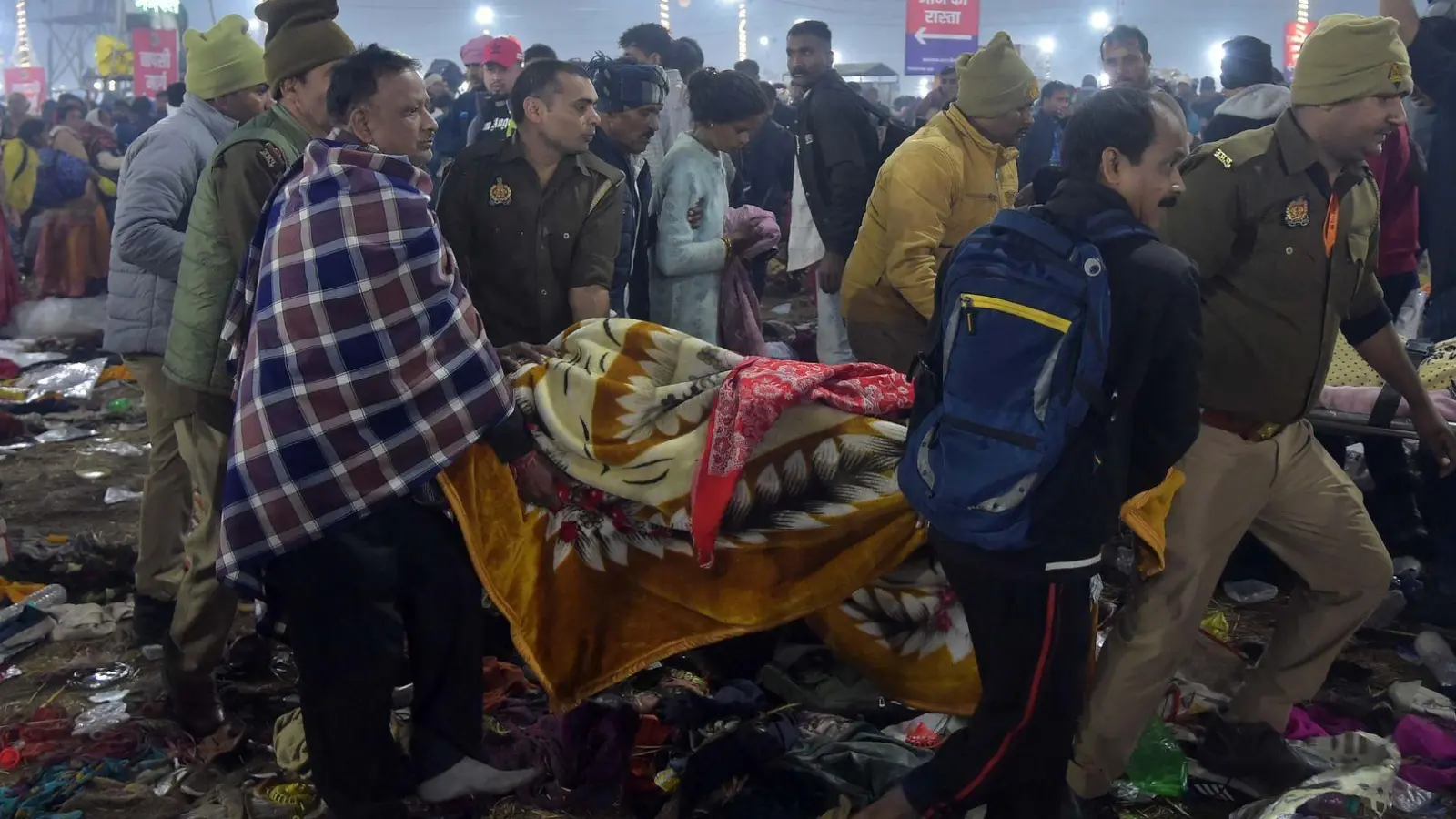 Nach einer Massenpanik tragen Helfer Opfer weg. (Foto: Str./XinHua/dpa)