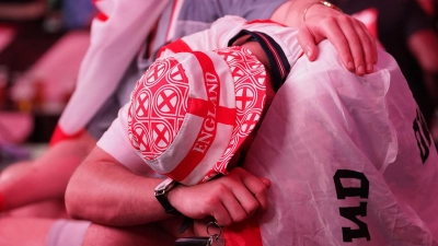 Ein England-Fan kauert traurig in eine Flagge gehüllt. (Foto: Gareth Fuller/PA Wire/dpa)