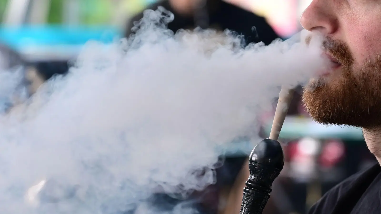 Ein Mann raucht in einer Shisha-Bar eine Wasserpfeife. (Foto: Bernd Weißbrod/dpa)