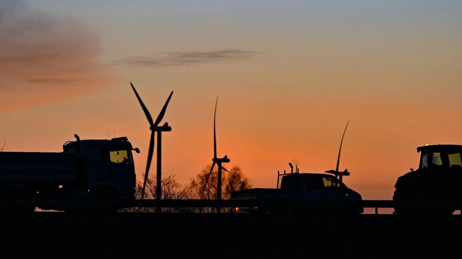 Ein Speditionsunternehmer mit seinem Lkw, ein Handwerker mit seinem Transporter und ein Landwirt mit seinem Traktor blockieren die Auffahrt einer Autobahn. (Foto: Patrick Pleul/dpa)