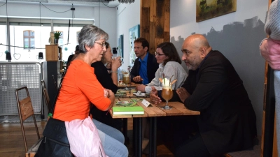 Speed-Dating mit den Grünen: Im Ansbacher Café Karl kamen am Freitag Bürgerinnen und Bürger mit dem Bundesvorsitzenden Omid Nouripour (rechte Seite, vorne), der Bezirkstagskandidatin Lisa Renz-Hübner (rechte Seite, Mitte) und dem Landtagskandidaten Martin Stümpfig ins Gespräch. (Foto: Philipp Zimmermann)