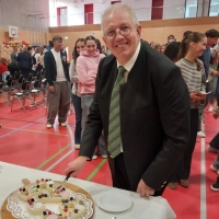 Schulleiter Uwe Nickel schneidet den Geburtstagskuchen an. (Foto: Katrin Merklein)
