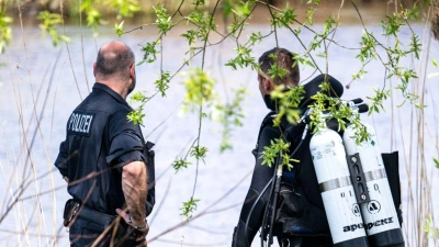 Ein Taucher der Polizei steigt in die Oste. (Foto: Sina Schuldt/dpa)