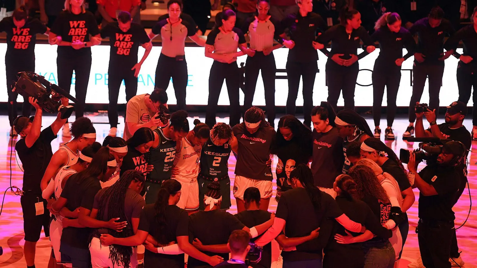 Die Teams der Connecticut Sun und der Phoenix Mercury verschränken vor einem Spiel der WNBA die Arme zu Ehren von Brittney Griner. (Foto: Sarah Gordon/The Day/AP/dpa)