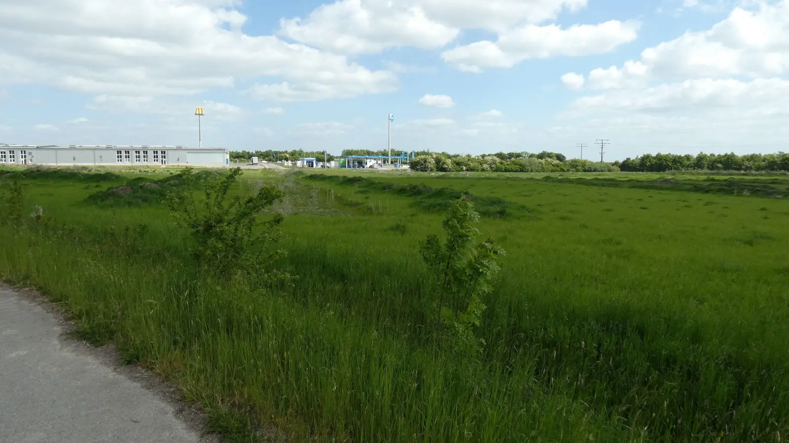 Abschnitt zwei des Gewerbeparks schließt südlich an den bereits bebauten Bereich an. In Hintergrund sind die Tankstelle, eine Firmenhalle und das Symbol des benachbarten Schnellrestaurants zu sehen. (Foto: Karl-Heinz Gisbertz)