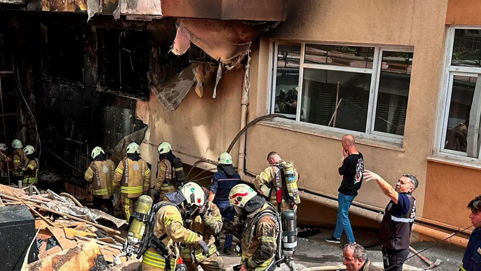 Feuerwehrleute sind nach dem Brand in einem Nachtclub im Einsatz. (Foto: Uncredited/IHA/AP/dpa)