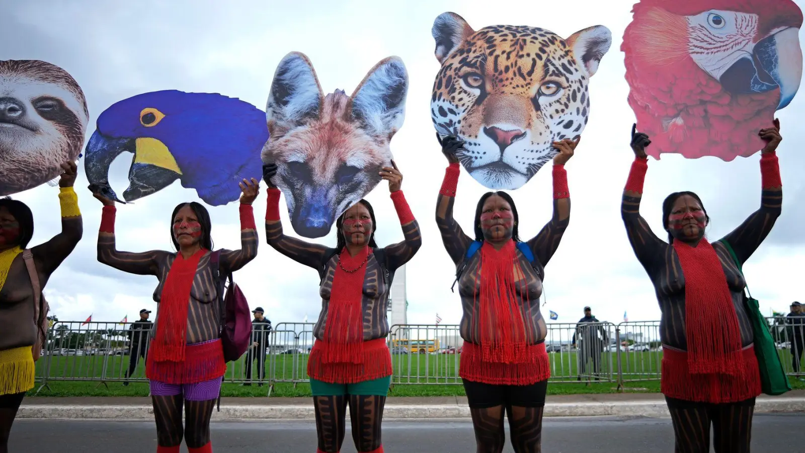 Indigene Frauen halten in Brasilien Tierbilder hoch, die die biologische Vielfalt repräsentieren sollen. Die Frauen protestieren gegen Pläne, nach denen Indigenen ein Teil ihres Landes weggenommen würde. (Foto: Eraldo Peres/AP/dpa)