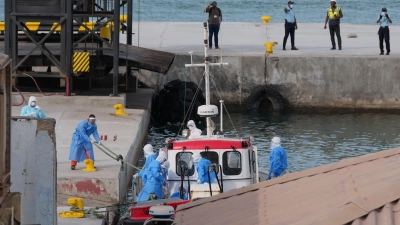 Gesundheitspersonal in Schutzkleidung evakuiert Patienten vom Kreuzfahrtschiff „Hondius“ in einem Hafen.  (Foto: Misper Apawu/AP/dpa)
