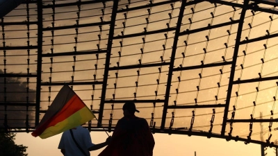 Fußball, UEFA Euro 2024, Deutschland – Ungarn, Vorrunde, Gruppe A, 2. Spieltag. Zuschauer mit Deutschlandfahne verlassen im Sonnenuntergang die Fanzone im Olympiapark nach dem Spiel. Die Fanzone im Münchner Olympiapark wird am Mittwoch nur eingeschränkt geöffnet sein. (Foto: Karl-Josef Hildenbrand/dpa)