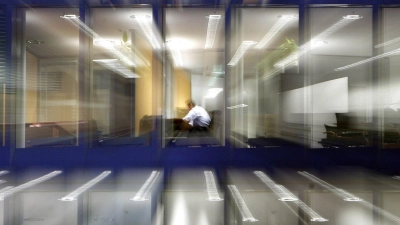Ein Arbeitnehmer im abendlichen Büro. Die Identifikation mit dem Beruf nimmt laut einer neuen Umfrage ab. (Symbolbild) (Foto: Frank Rumpenhorst/dpa)
