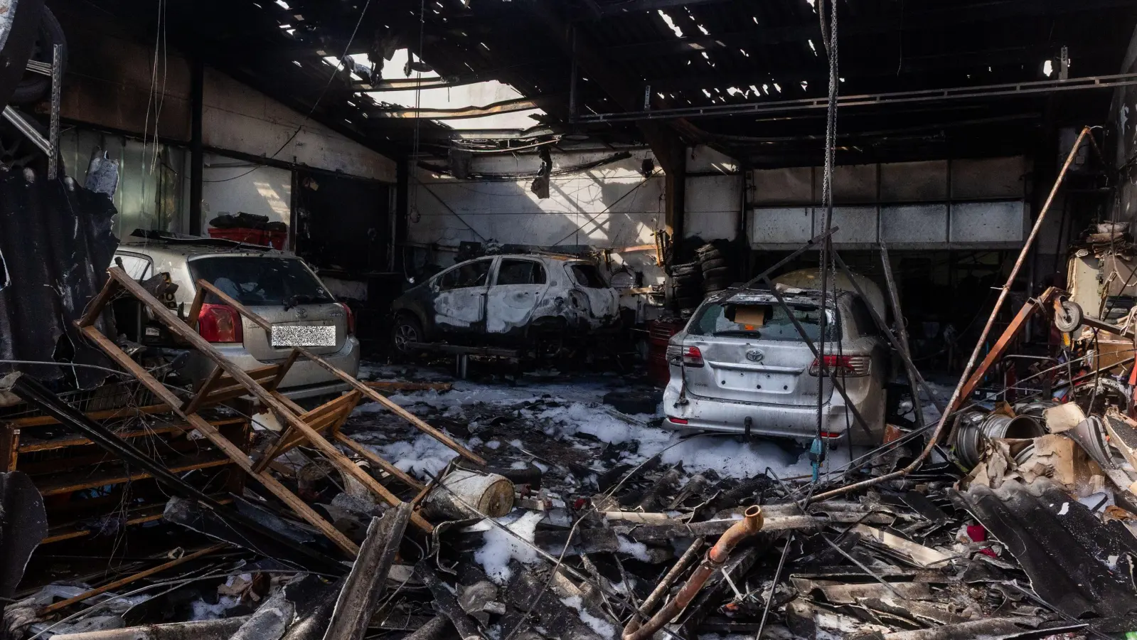 Die Werkstatthalle und das Reifenlager am Morgen nach dem Brand. Eines der Autos, dass vom Umweltamt der Stadt Ansbach beanstandet wurde, steht in der Lackierkabine. (Foto: Evi Lemberger)