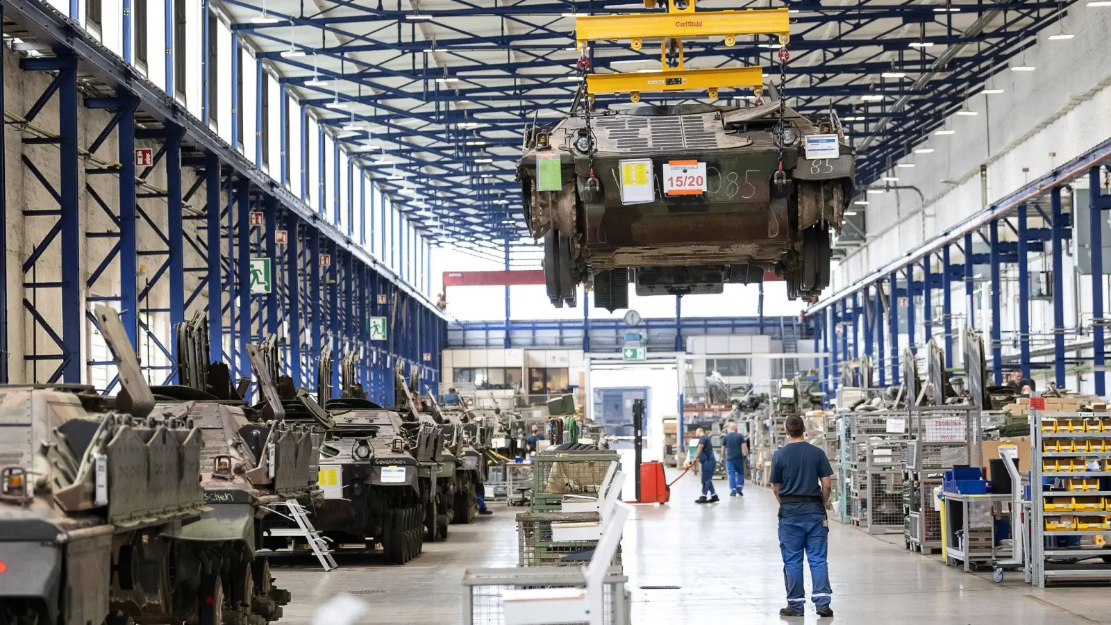 Ein Panzer vom Typ Marder schwebt in der Fertigungshalle von Rheinmetall. Der Rüstungskonzern ist im Wettbewerb um einen Milliardenauftrag weiter im Rennen. (Foto: Swen Pförtner/dpa)