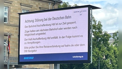 Ein Hinweis macht die Besucher des Katholikentags in Würzburg auf die wenig später aufgehobene Sperrung des Bahnhofs in Aschaffenburg aufmerksam.  (Foto: Angelika Resenhoeft/dpa)