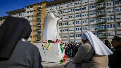 Gläubige versammeln sich vor der Gemelli-Klinik in Rom, um für den Papst zu beten. (Foto: Andrew Medichini/AP/dpa)