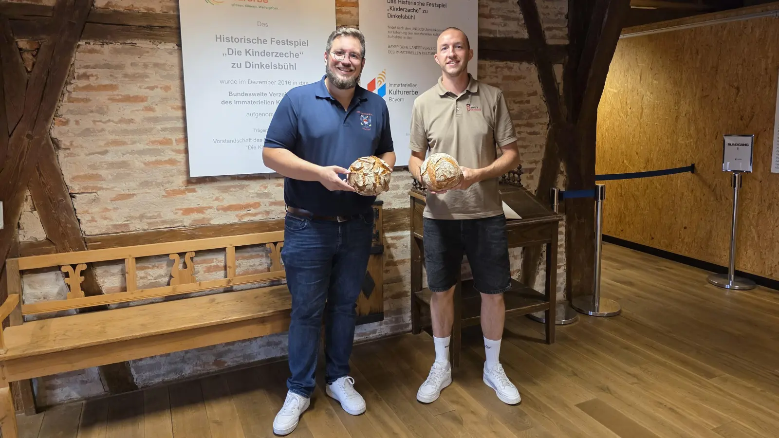 Freuten sich über den Erfolg der Spendenaktion zugunsten der Kinderzeche (von links): Maximilian Mattausch, Sprecher des Festspielvorstandes, der in seinen Händen ein Dinkelsbühler Bauernbrot hält, sowie der Juniorchef der Bäckerei, Jan Ahamer, hier im Bild mit einem Exemplar des Schwedischen Landsknechtsbrotes. (Foto: Markus Weinzierl)