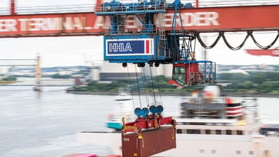 Ein Container wird auf dem Container-Terminal Altenwerder im Hamburger Hafen mit einer Containerbrücke auf ein Schiff geladen. (Foto: Daniel Reinhardt/dpa)