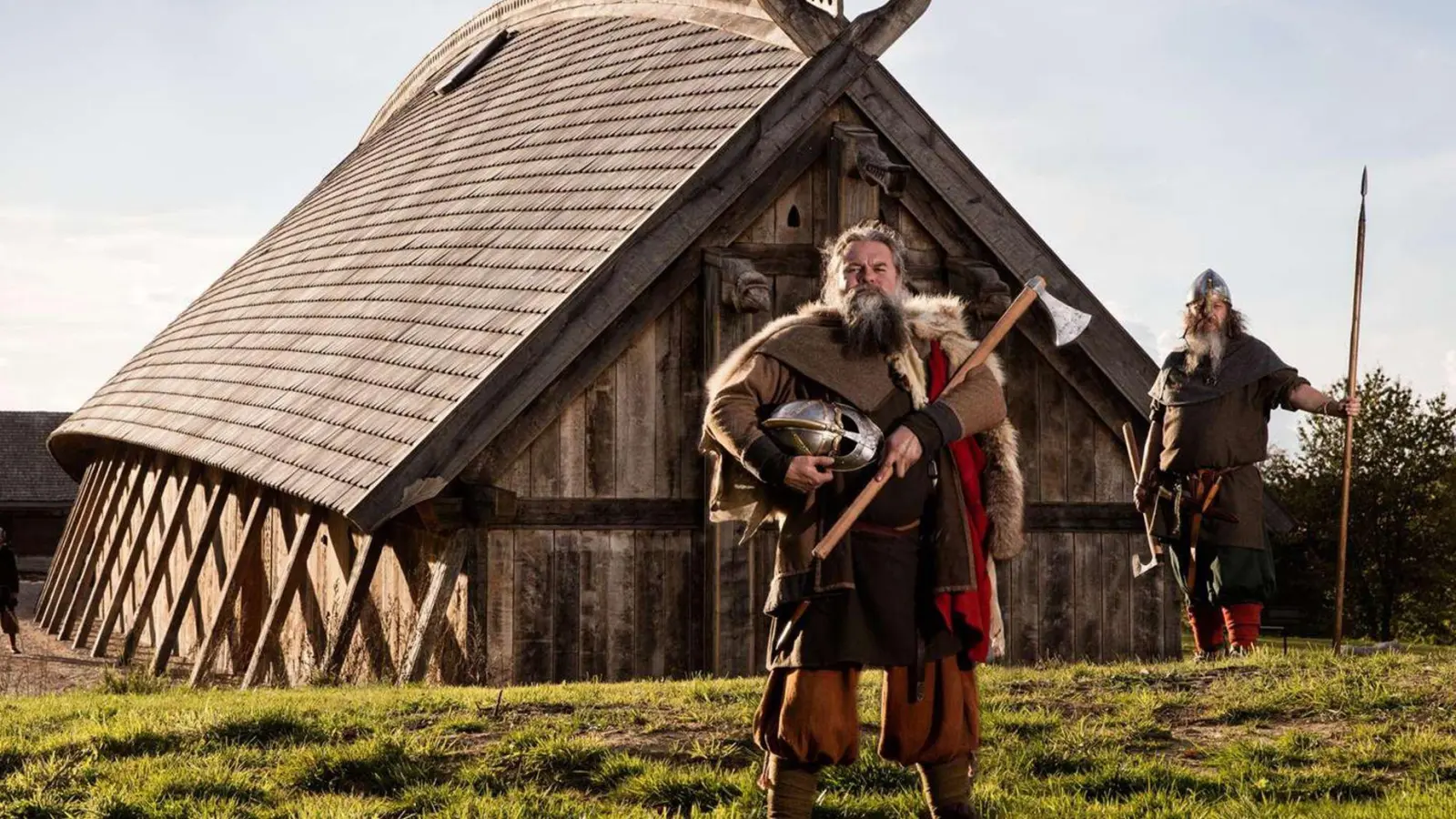 Zeitreise: Als Wikinger verkleidete Schauspieler stehen vor der Königshalle im „Land der Legenden“. (Foto: Sagnlandet Lejre/Visit Fjordlandet/dpa-tmn)