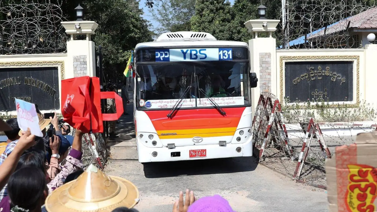 Familienmitglieder und Freunde von Häftlingen stehen vor dem Insein-Gefängnis in Yangon, als ein Bus mit Freigelassenen vom Gelände fährt. (Foto: Thein Zaw/AP/dpa)