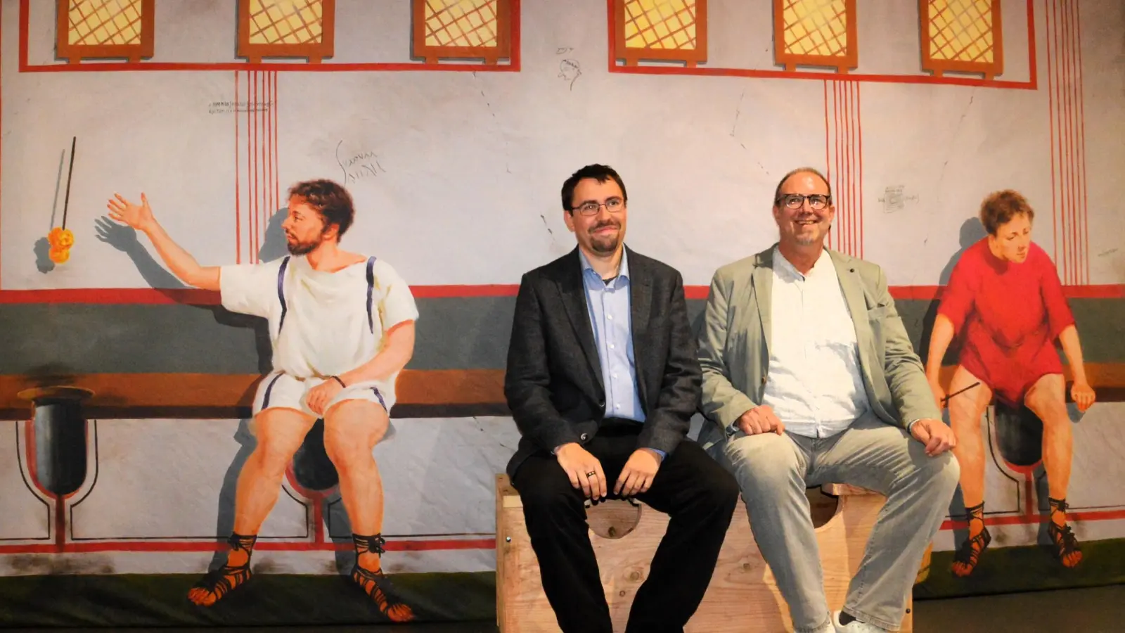 Limeseumssleiter Dr. Matthias Pausch (rechts) und der wissenschaftliche Volontär Alexander Scholz testen die nachgebaute Latrinenbank. Sie ist Teil der Sonderausstellung zur Kulturgeschichte des Toilettengangs. (Foto: Peter Tippl)