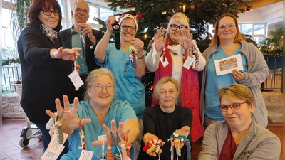 Die „strickenden Biester“ der Kiliani-Kinik und ihre Helfer zeigen die Glückswürmchen, die sie ihren Patienten geschenkt haben (hinten, von links): Kathrin Müller, Martin Vitzithum, Manu Schneppat, Malgorzata Schuster, und Rosi Kreitlein, sowie (vorne, von links): Felicitas Limberger, Heidi Leibner und Andrea Mend. (Foto: K. Merklein)