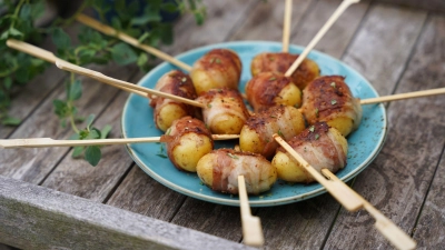 „Grillinge“: Das ist die Bezeichnung für in Speck eingerollte und am Spieß gegrillte Drillinge. (Foto: KMG/die-kartoffel.de/dpa-tmn)