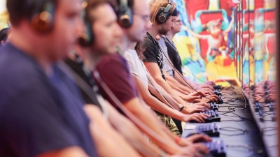 Messebesucher der Computer- und Videospielemesse „Gamescom“ testen ein Computerspiel. (Foto: Oliver Berg/dpa)