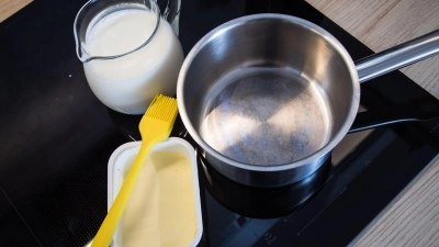 Butter am Rand eines Kochtopfs soll das Überkochen von Milch verhindern. (Foto: Christin Klose/dpa-tmn)