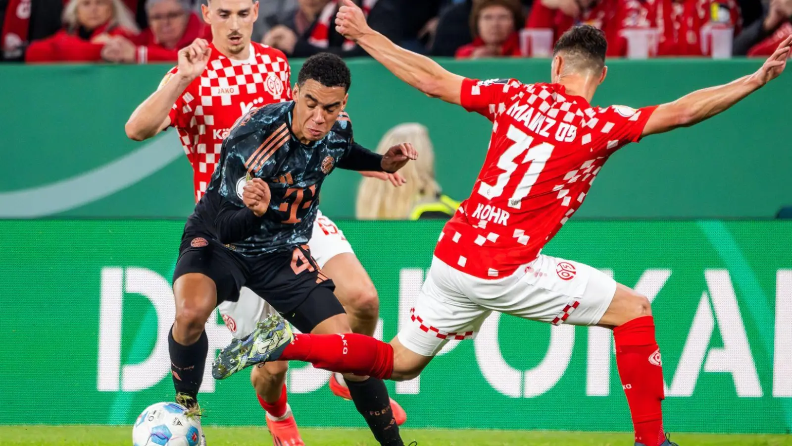 Der Münchner Jamal Musiala (M) ist nur schwer vom Ball zu trennen. (Foto: Torsten Silz/dpa)