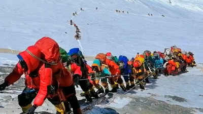 In einer langer Schlange gehen Bergsteiger auf einem Pfad knapp unterhalb von Lager vier auf dem Mount Everst. Bald ist ein Trecking-Gerät für jeden Pflicht. (Foto: Rizza Alee/AP/dpa)