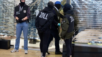 Zollbeamte stehen vor einem Nagelstudio in der Neumarktgalerie in der Innenstadt von Köln. (Foto: Henning Kaiser/dpa)