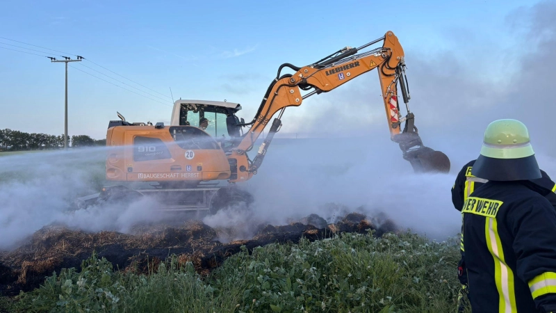 Mit Hilfe von schwerem Gerät zogen die Einsatzkräfte den Strohhaufen bei Markt Nordheim auseinander, um an die Glutnester zu kommen. Eine rauchige Angelegenheit. (Foto: Kreisfeuerwehrverband)