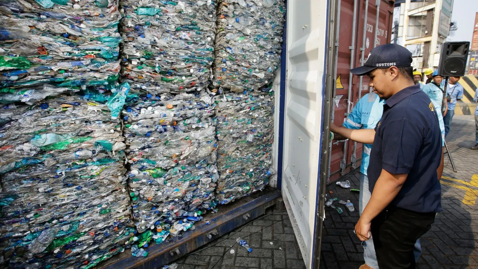 Ein Zollbeamter verschließt am Hafen von Tanjung Priok einen Container mit Plastikmüll. (Foto: Achmad Ibrahim/AP/dpa)