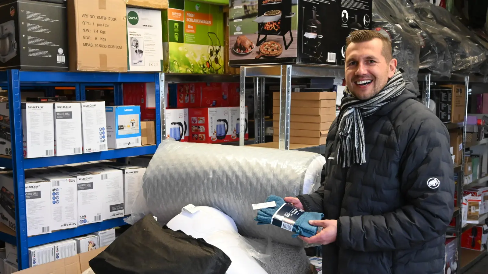 Jens Fleischmann inmitten seines Retouren-Lagers. Das Handtuch in seinen Händen wurde zum Beispiel originalverpackt zurückgeschickt. (Foto: Anna Beigel)