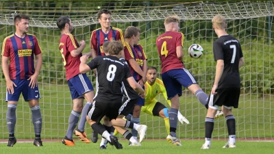 Der Segringer Julian Frickinger (Nr. 8) nimmt Maß und verwandelt den Freistoß zum 1:0, beobachtet von seinem Teamkollegen Noah Görgler (Nr. 7). Die Feuchtwanger Mauer steht weit auseinander und auch TuS-Keeper Dimitrios Melidis kann den Einschlag nicht verhindern. (Foto: Martin Rügner)