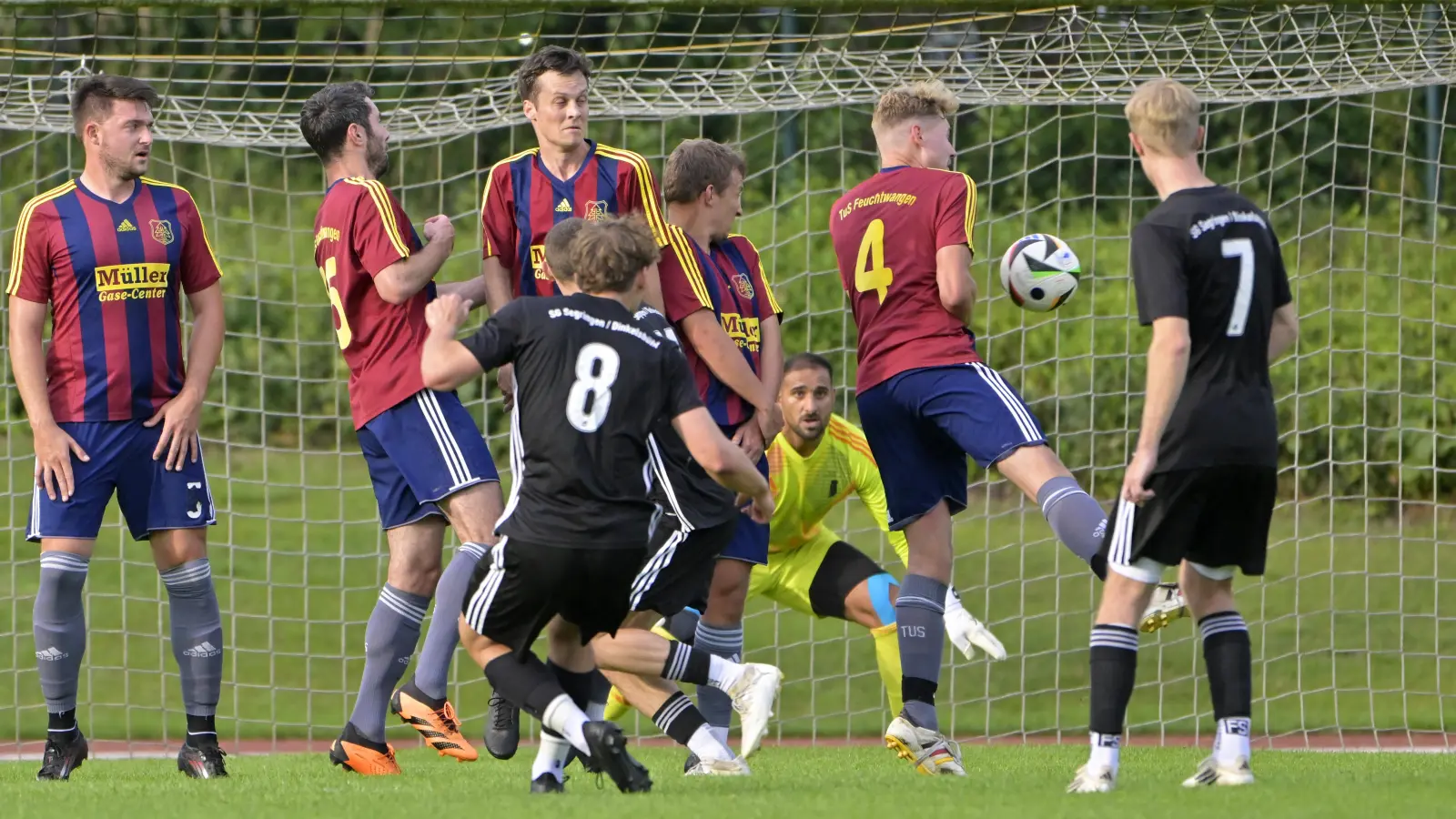 Der Segringer Julian Frickinger (Nr. 8) nimmt Maß und verwandelt den Freistoß zum 1:0, beobachtet von seinem Teamkollegen Noah Görgler (Nr. 7). Die Feuchtwanger Mauer steht weit auseinander und auch TuS-Keeper Dimitrios Melidis kann den Einschlag nicht verhindern. (Foto: Martin Rügner)