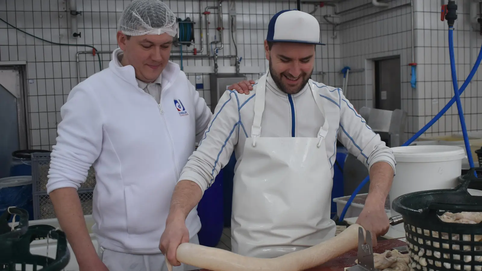 Geschäftsführer Maximilian Hartl (links) und Produktionsleiter Sebastian Thürauf zeigen die Verarbeitung eines Schweinedarms. (Foto: Ute Niephaus)