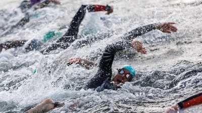 Patrick Lange (M, blaue Kappe) Triathlet aus Deutschland, startet mit weiteren Triathleten bei der Schwimmetappe beim Datev Challenge Roth. (Foto: Daniel Karmann/dpa)