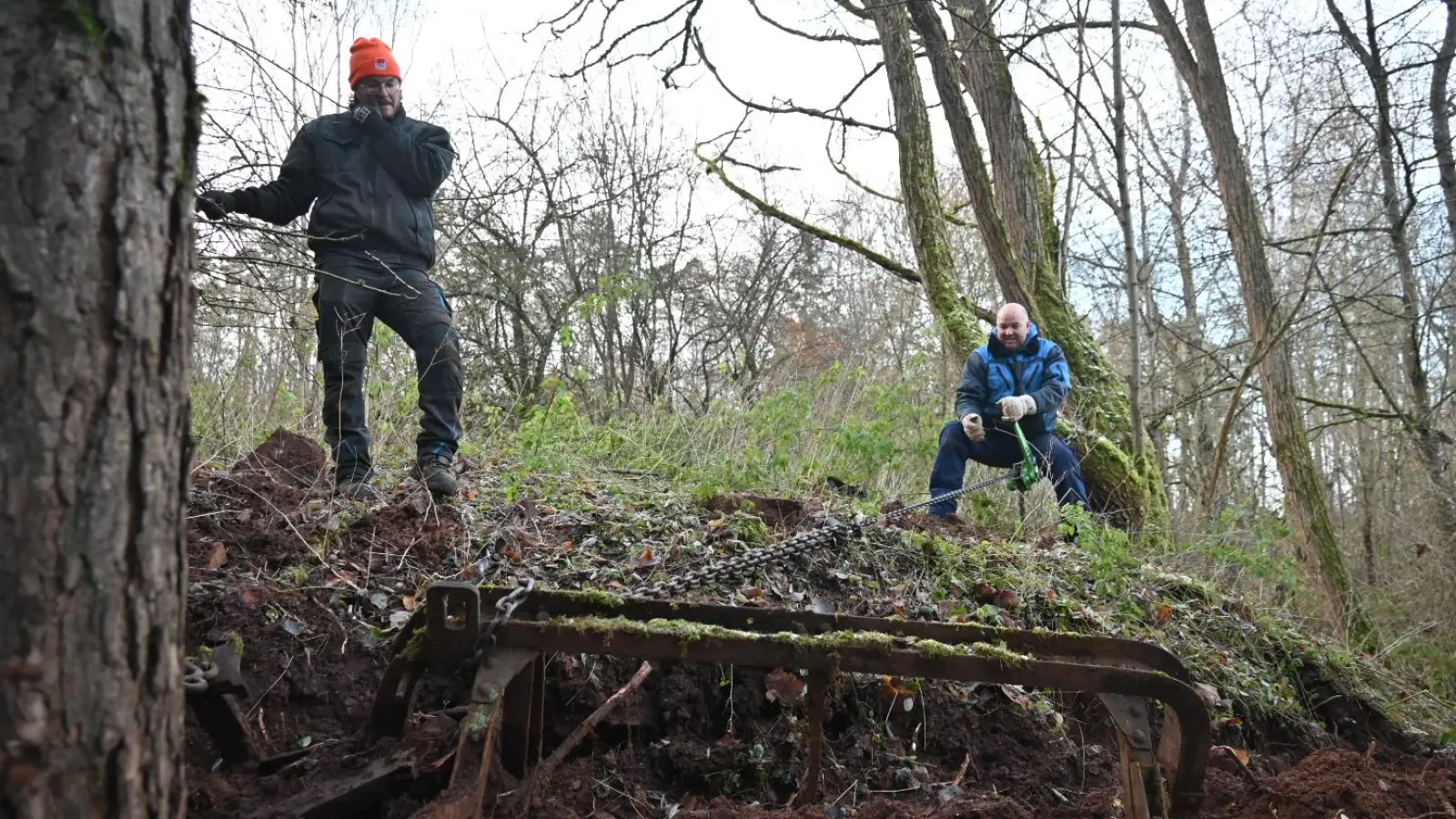 Handarbeit: Mühsam mussten die im Wald vergrabenen Loren geborgen werden. Jonas Trenner (links) half Jürgen Wening (am Kettenzug) und dessen Schulfreund, seinem Vater Harald Trenner. (Foto: Wolfgang Grebenhof)