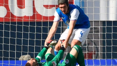 Damian Roßbach hilft Torwart Markus Kolke hoch. Der Rostocker Keeper patzte vor dem 1:1-Ausgleich. (Foto: Gregor Fischer/dpa)