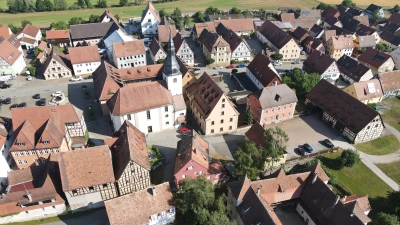 Der Platz vor der Schlossscheune hat sich verändert, Die alte Post, die auf dem Foto noch steht, wurde inzwischen abgerissen. Als Ersatzbau soll ein Multifunktionsgebäude entstehen. (Foto: Gemeinde Neuhof\Konrad Willar)