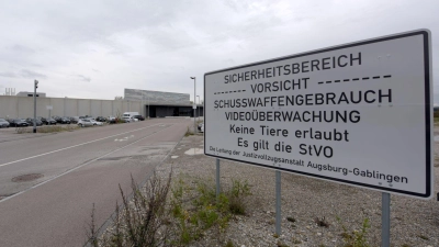 Ein Warnschild steht vor der Justizvollzugsanstalt Augsburg-Gablingen. Gegen Mitarbeiter der Haftanstalt wird wegen des Verdachts der Körperverletzung ermittelt. (Archivbild) (Foto: Stefan Puchner/dpa)